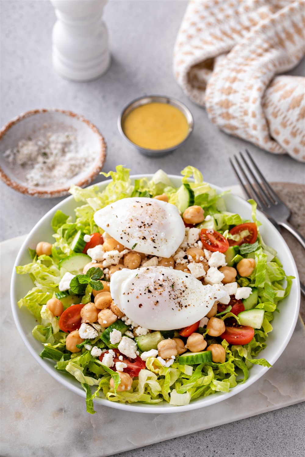 A fresh Mediterranean plate with greens, chickpeas, and egg